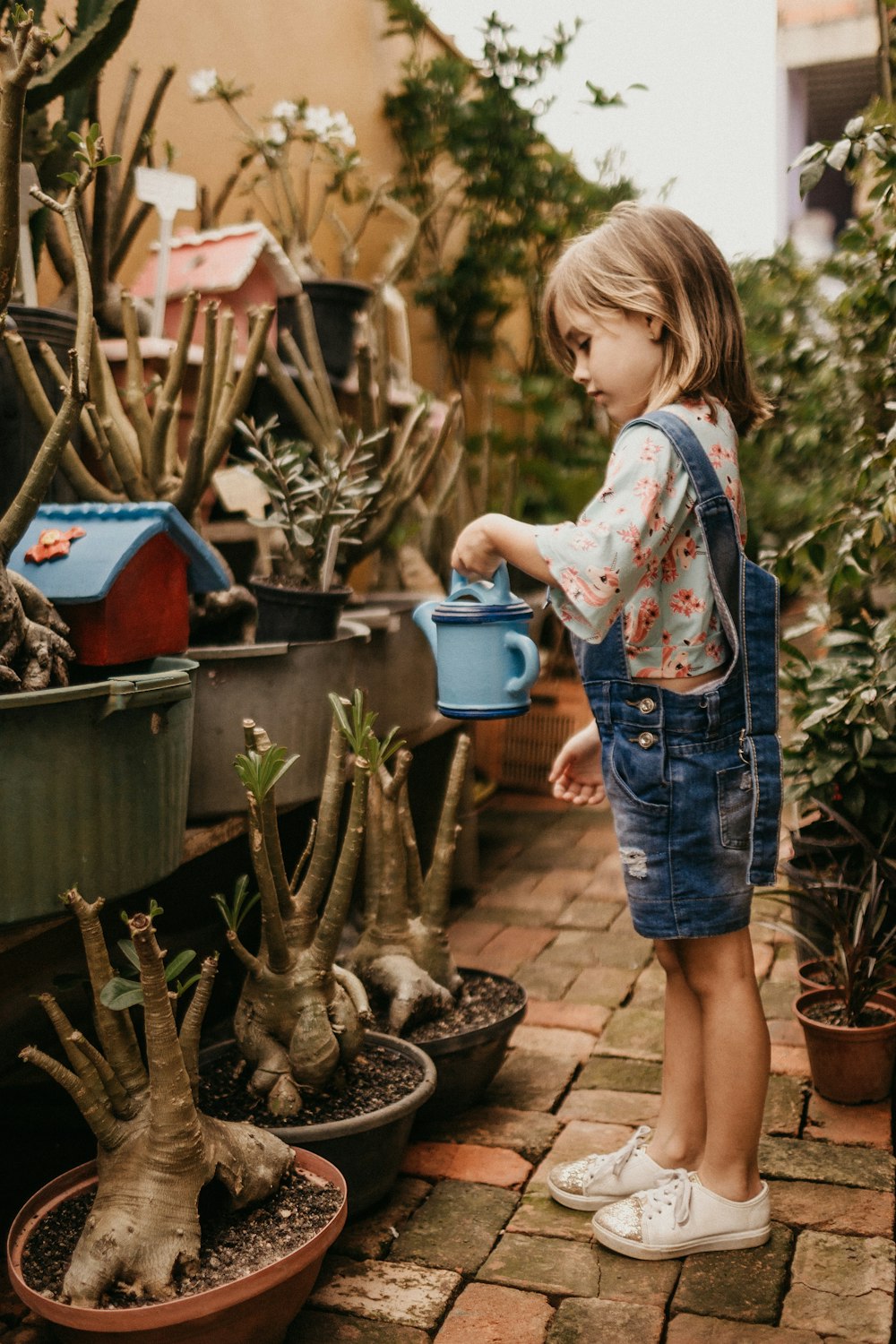 Toddler watering plants in a garden