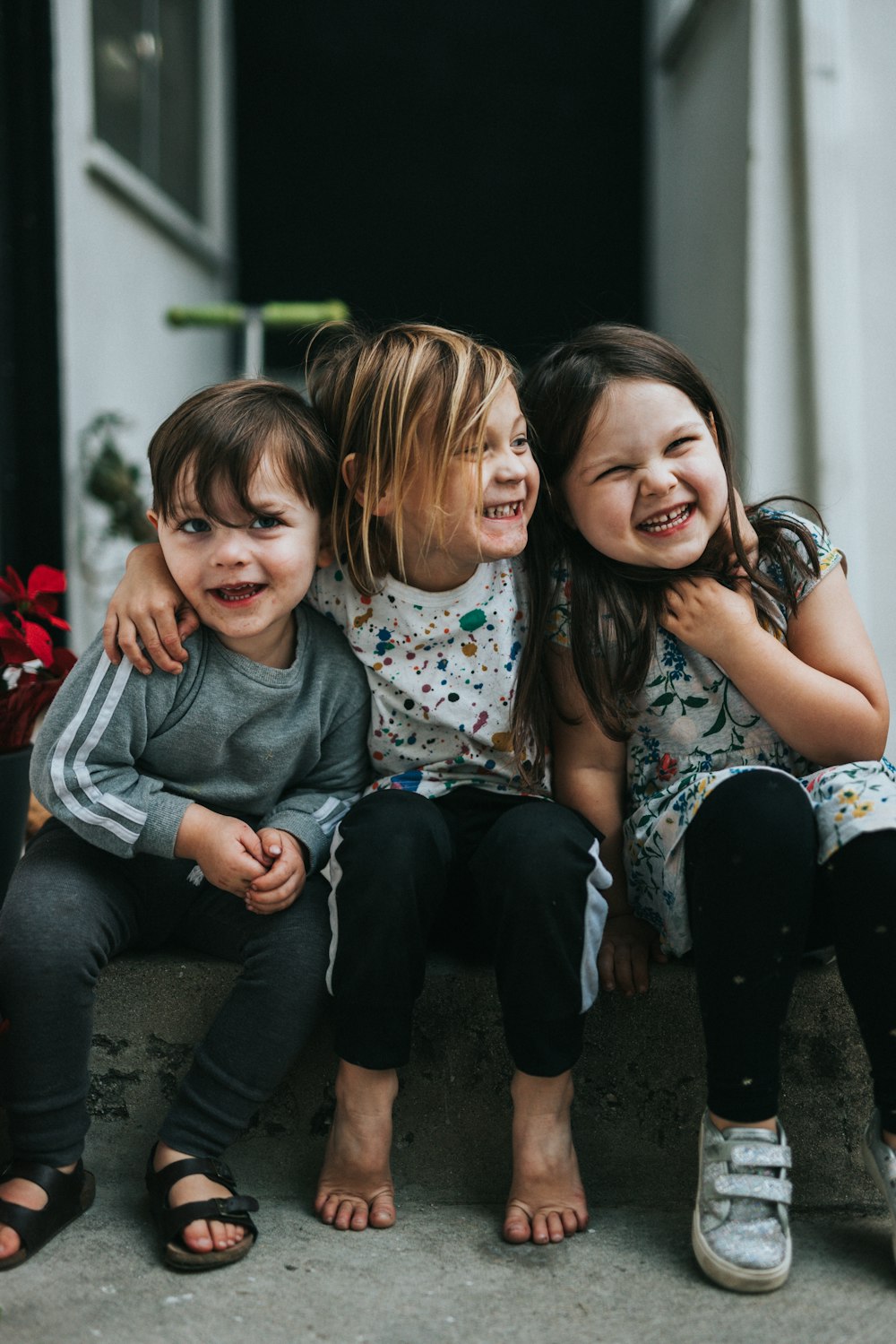 Three toddlers sitting together, smiling