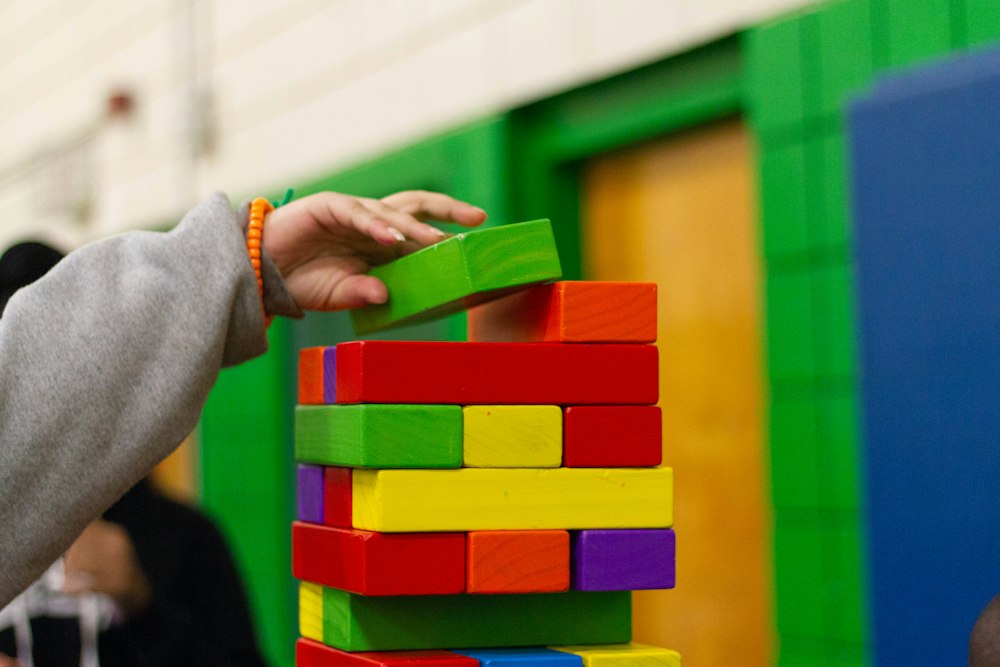 Child stacking colorful wooden blocks